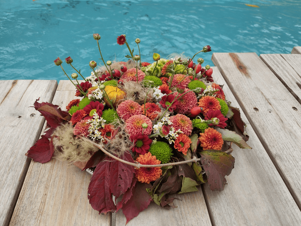 Un gâteau de chrysanthème et de physalis, orné de branches de feuilles de vigne vierge rougies par l'automne