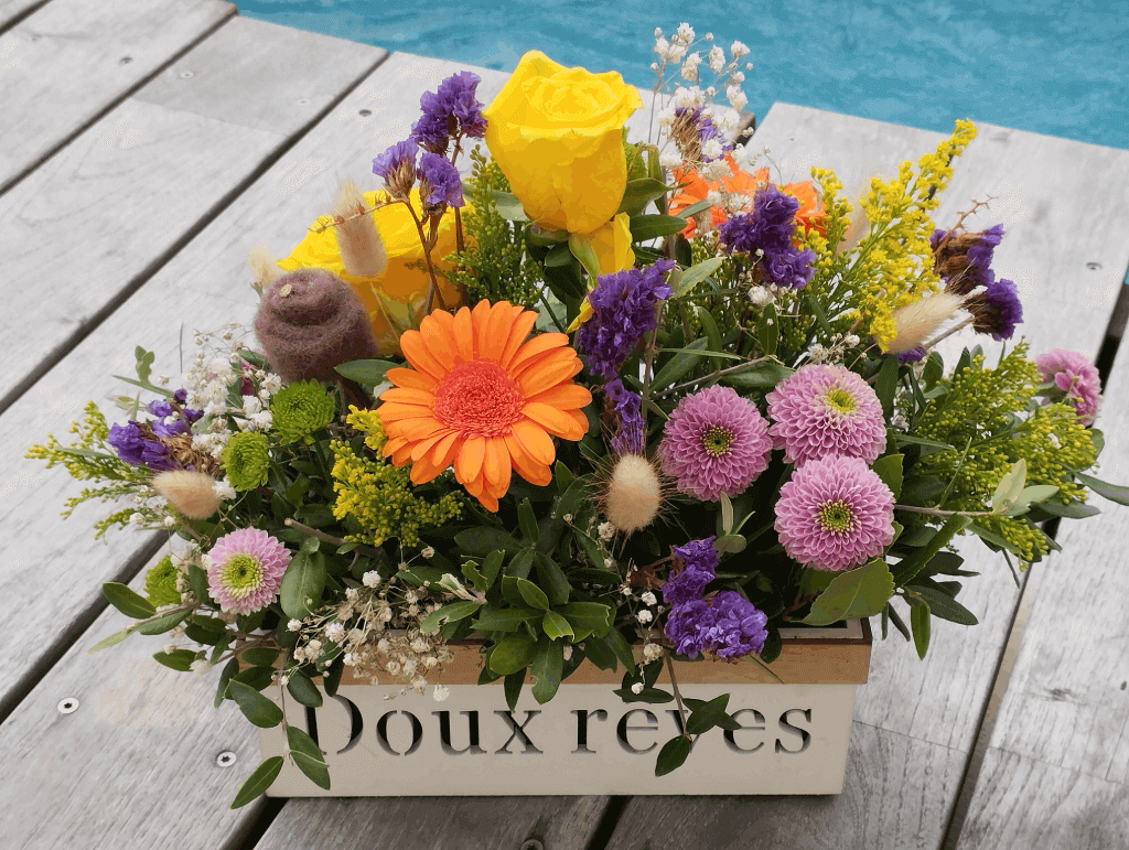Les Compos de Pauline : composition florale contrastée pour une décoration de chambre joyeuse : Gerbera orange, statice violette, Santini mauves et verts, solidago, gypsophile blanc et branches d'olivier pour la sérénité.